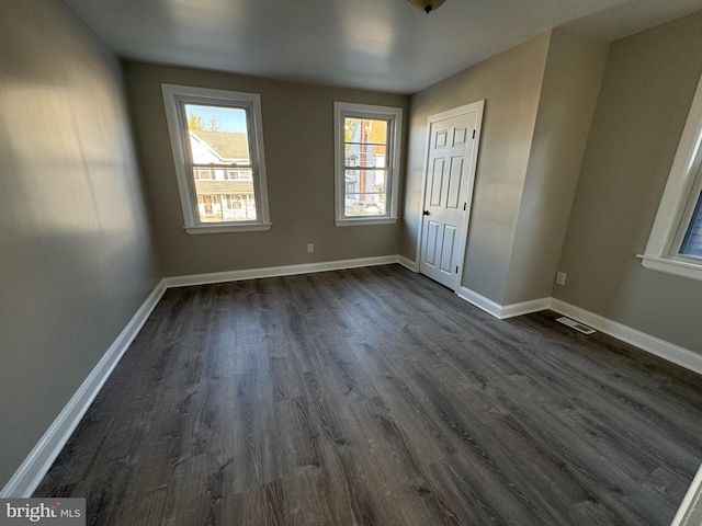 unfurnished bedroom with dark hardwood / wood-style flooring