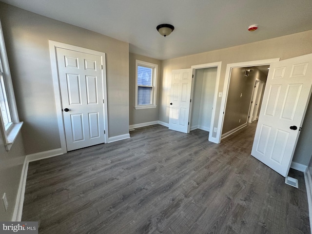 unfurnished bedroom with dark wood-type flooring