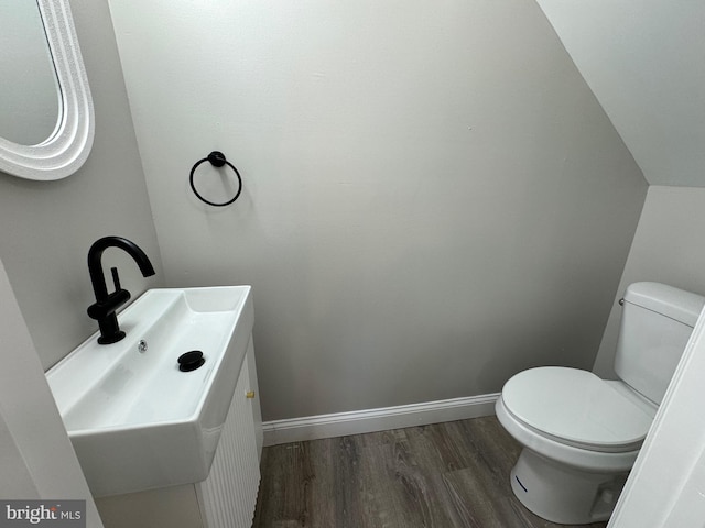 bathroom with toilet, hardwood / wood-style flooring, and vanity