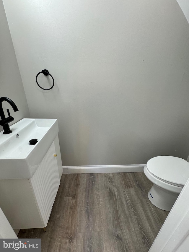 bathroom with vanity, wood-type flooring, and toilet