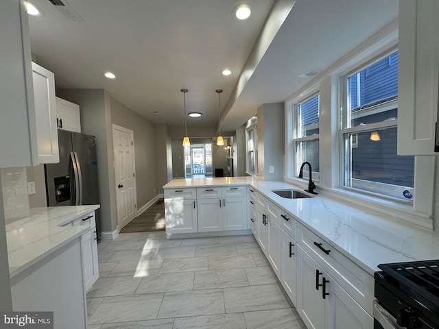 kitchen featuring sink, white cabinets, kitchen peninsula, and tasteful backsplash