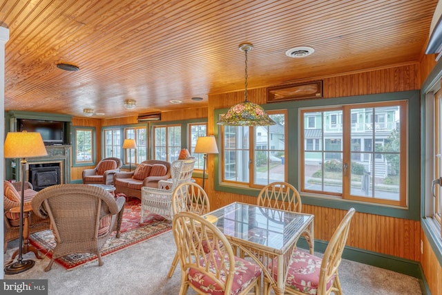 carpeted dining room with wooden walls and wood ceiling