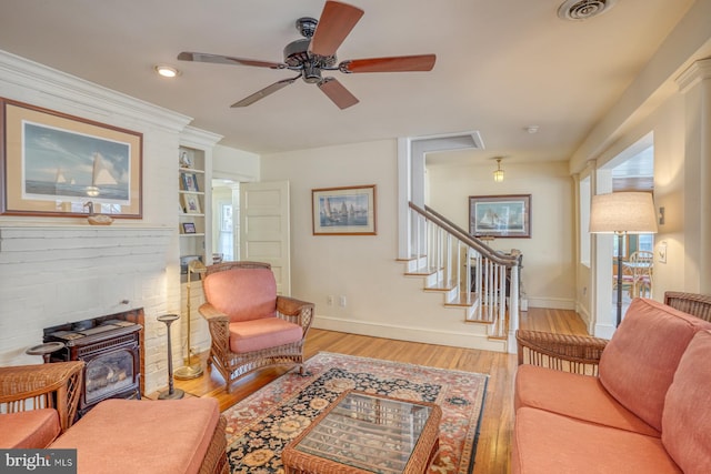 living room with ceiling fan, light hardwood / wood-style floors, and built in shelves