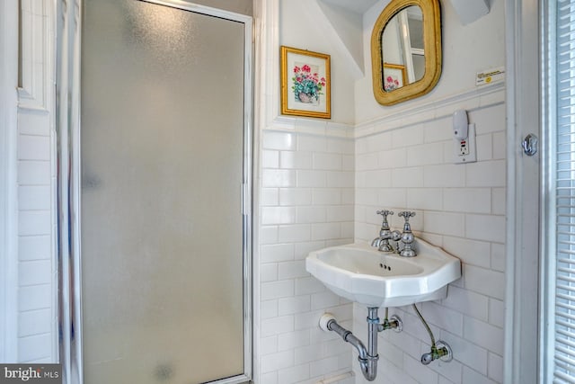 bathroom featuring tile walls, sink, and walk in shower