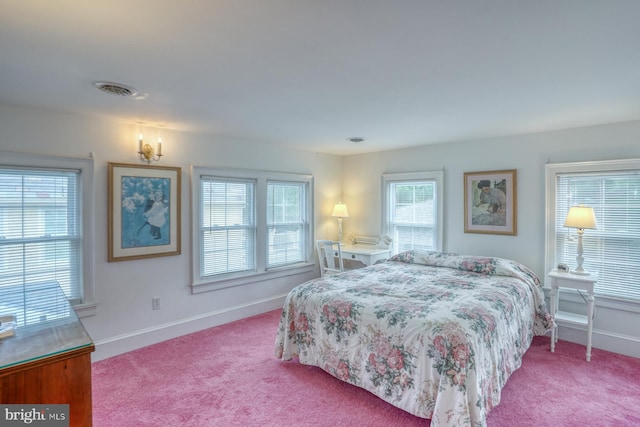 bedroom featuring multiple windows and light colored carpet