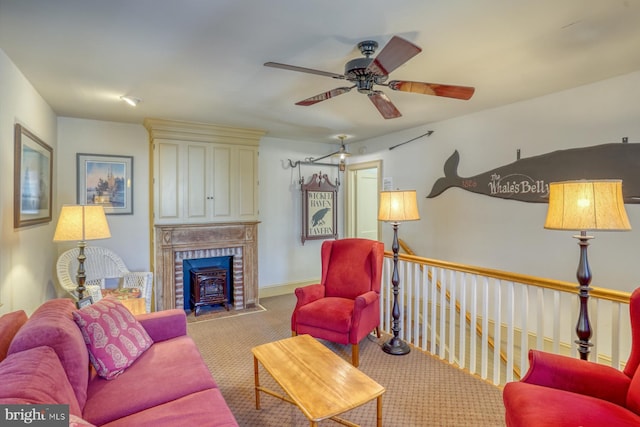 carpeted living room with a wood stove and ceiling fan