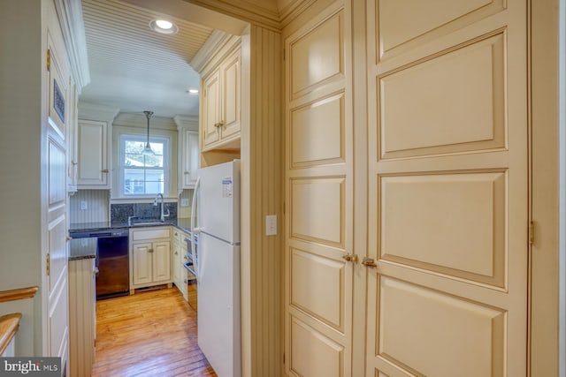 kitchen featuring black dishwasher, hanging light fixtures, dark stone countertops, white fridge, and light hardwood / wood-style floors