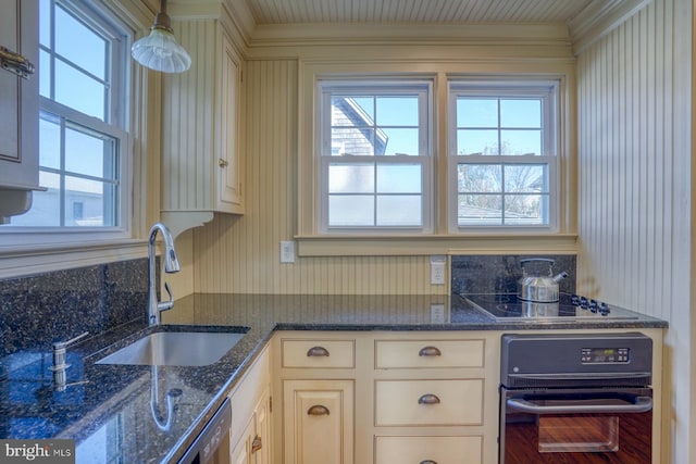 kitchen featuring sink, black appliances, cream cabinets, and dark stone counters