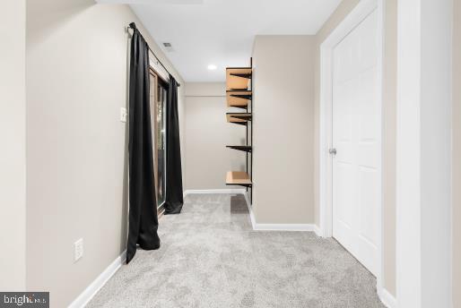 hallway featuring light colored carpet