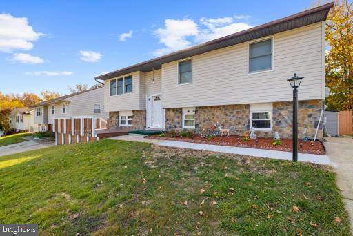 raised ranch featuring a front yard and a deck