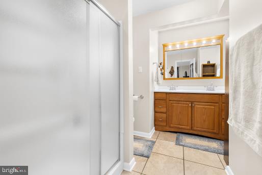 bathroom featuring vanity, tile patterned floors, and an enclosed shower