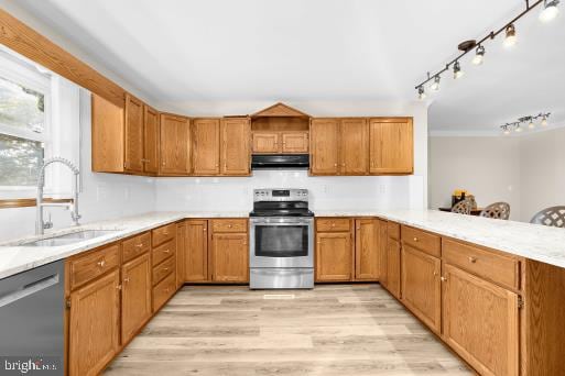 kitchen featuring kitchen peninsula, appliances with stainless steel finishes, sink, and light wood-type flooring