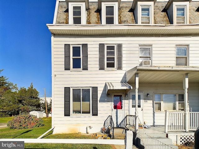 townhome / multi-family property featuring a porch and a front yard