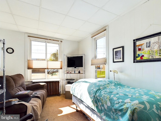 bedroom featuring radiator, carpet flooring, and a drop ceiling