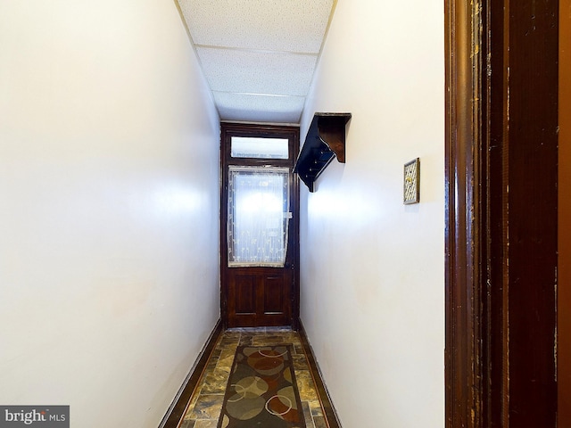 corridor with a paneled ceiling