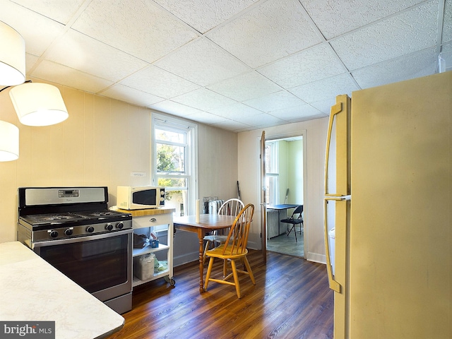 kitchen with a paneled ceiling, dark wood-type flooring, and white appliances