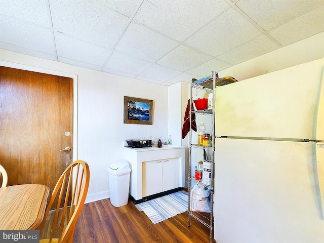 kitchen with white fridge, dark hardwood / wood-style floors, and a paneled ceiling