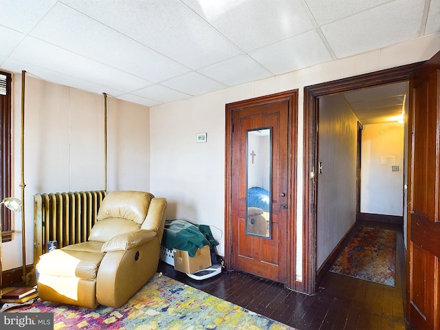 living area with radiator heating unit and dark hardwood / wood-style flooring