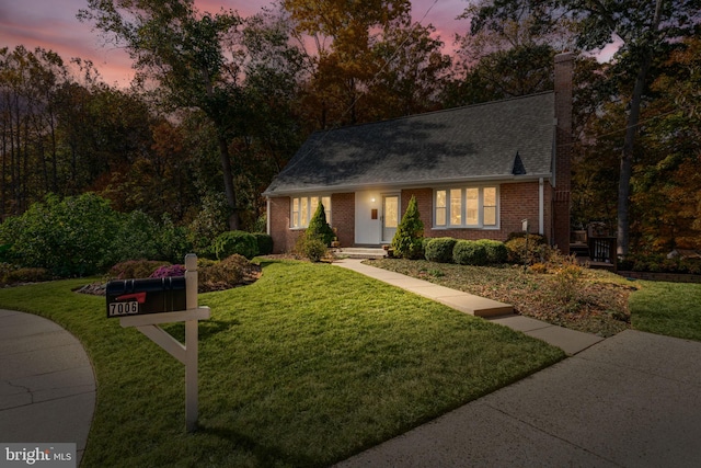 cape cod home with a lawn