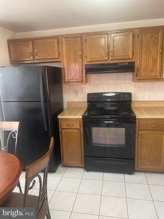 kitchen featuring backsplash, black appliances, and light tile patterned flooring