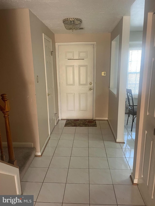 entryway featuring a textured ceiling and light tile patterned floors