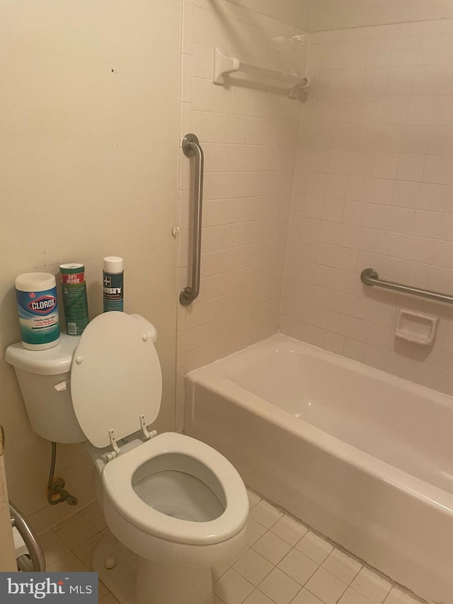 bathroom featuring tiled shower / bath, toilet, and tile patterned flooring