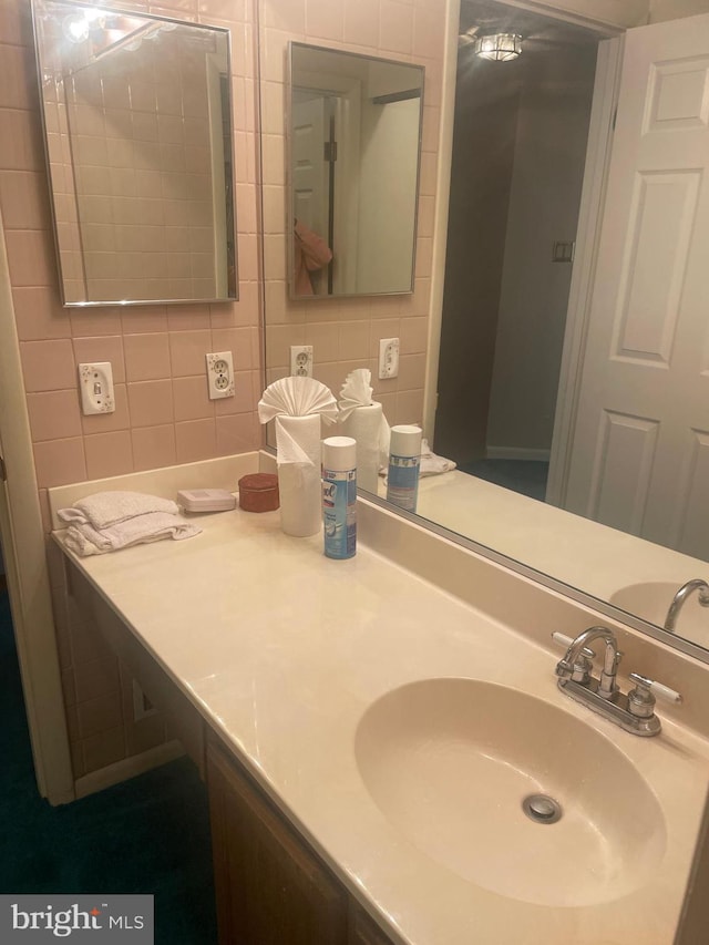 bathroom featuring tile walls, vanity, and backsplash