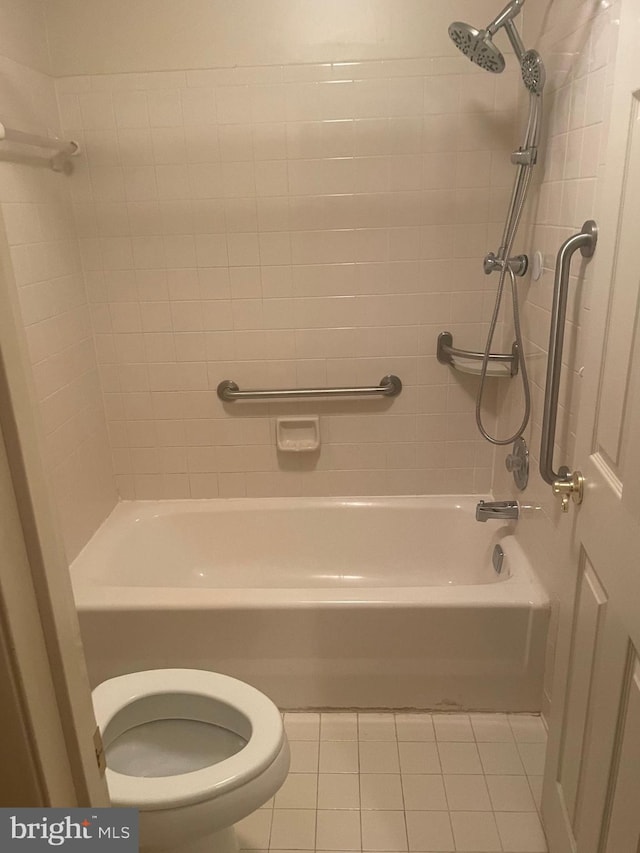 bathroom with toilet, tiled shower / bath combo, and tile patterned flooring