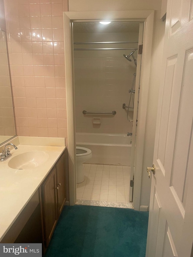 full bathroom featuring vanity, toilet, tiled shower / bath combo, and tile patterned flooring