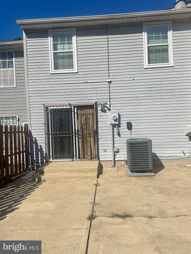 rear view of property with a patio area and central AC