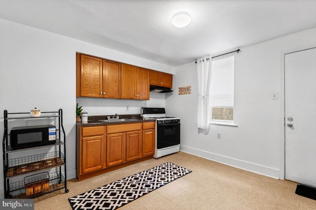 kitchen featuring white range oven and sink