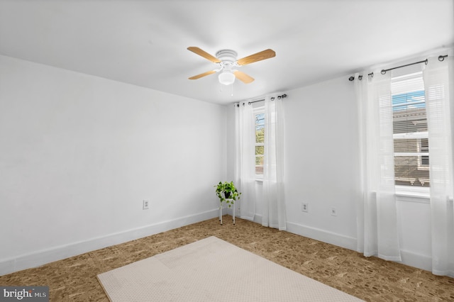 spare room featuring ceiling fan and a healthy amount of sunlight