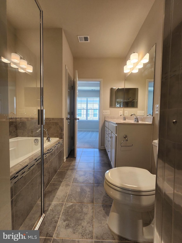 bathroom featuring toilet, vanity, and tiled tub