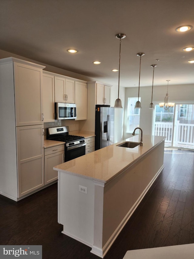 kitchen featuring a kitchen island with sink, appliances with stainless steel finishes, sink, and dark hardwood / wood-style flooring