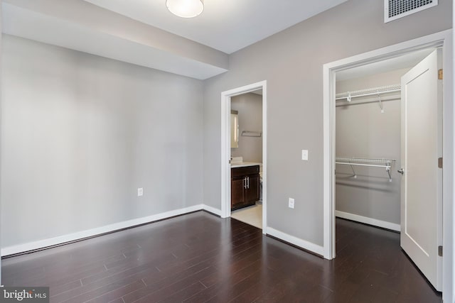 unfurnished bedroom featuring a closet and dark wood-type flooring