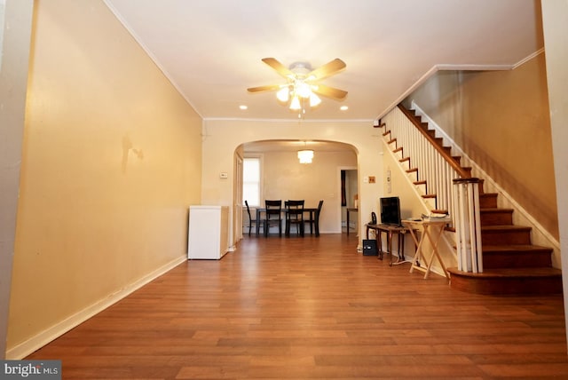 interior space with crown molding, wood-type flooring, and ceiling fan