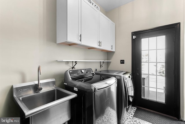 laundry area with cabinet space, independent washer and dryer, and a sink