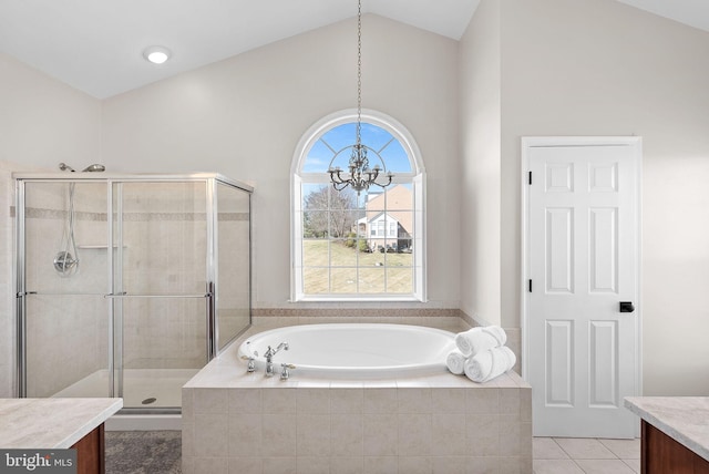 full bath featuring vanity, an inviting chandelier, lofted ceiling, a stall shower, and a garden tub