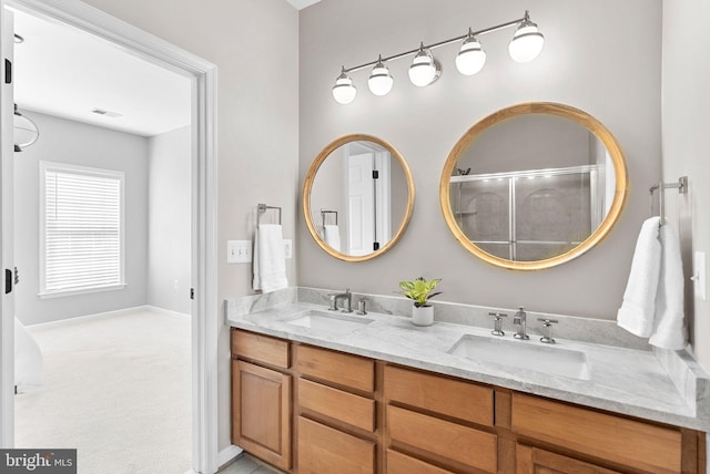 bathroom with double vanity, an enclosed shower, visible vents, and a sink