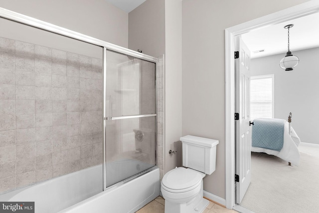 ensuite bathroom featuring baseboards, visible vents, enclosed tub / shower combo, ensuite bath, and toilet