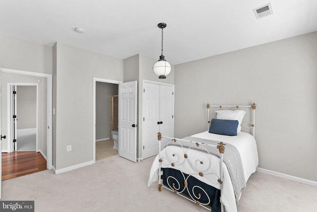 bedroom with visible vents, light carpet, baseboards, and a closet