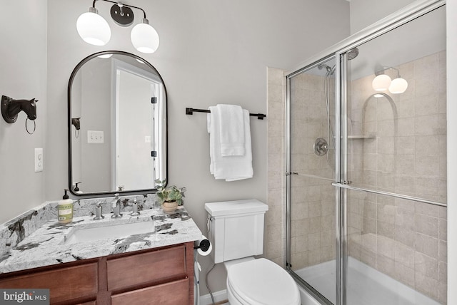 bathroom with vanity, toilet, and a stall shower