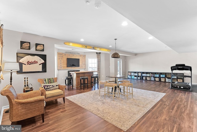 living area featuring recessed lighting, a dry bar, baseboards, and wood finished floors