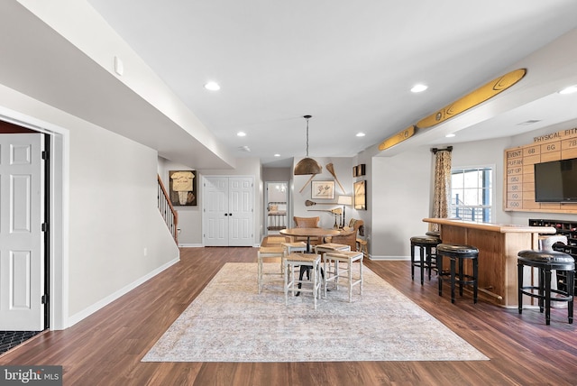 dining area with stairs, baseboards, and dark wood-style flooring