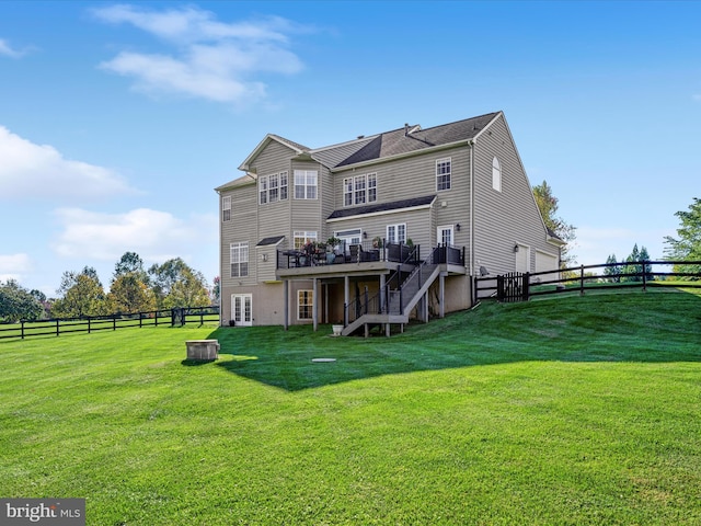 back of property featuring stairway, a yard, and fence