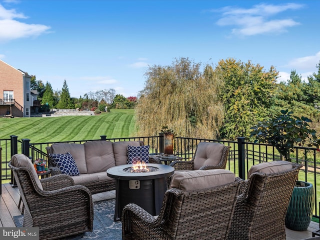 wooden terrace featuring a lawn and an outdoor living space with a fire pit