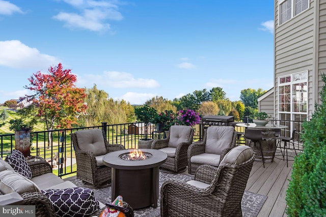 wooden terrace featuring an outdoor living space with a fire pit