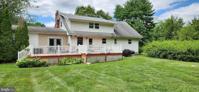 back of property with a wooden deck and a lawn