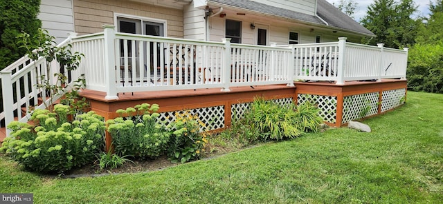 back of property with a wooden deck and a lawn