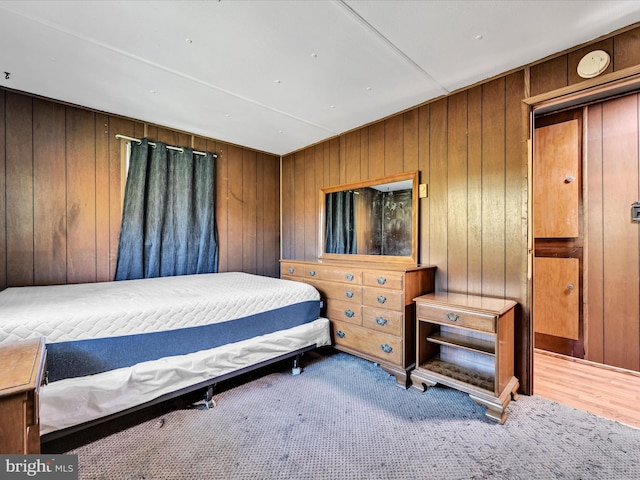 bedroom with wood walls and wood-type flooring